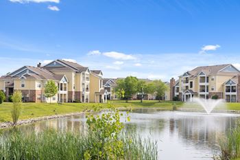 A row of houses with a fountain in front of them.